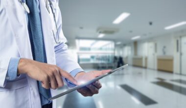 Close-up of a physician's hands holding a tablet, used in a post about healthcare startup Regard