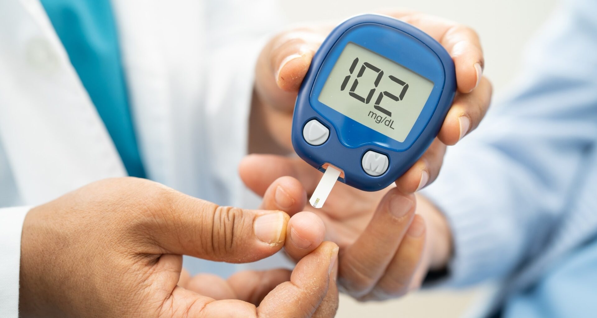 Doctor check diabetes from finger blood sugar level with finger lancet.
