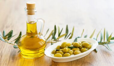 Olive oil and olive berries are on the wooden table