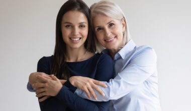 Portrait of smiling mature mother and beautiful millennial daughter hug look at camera posing together