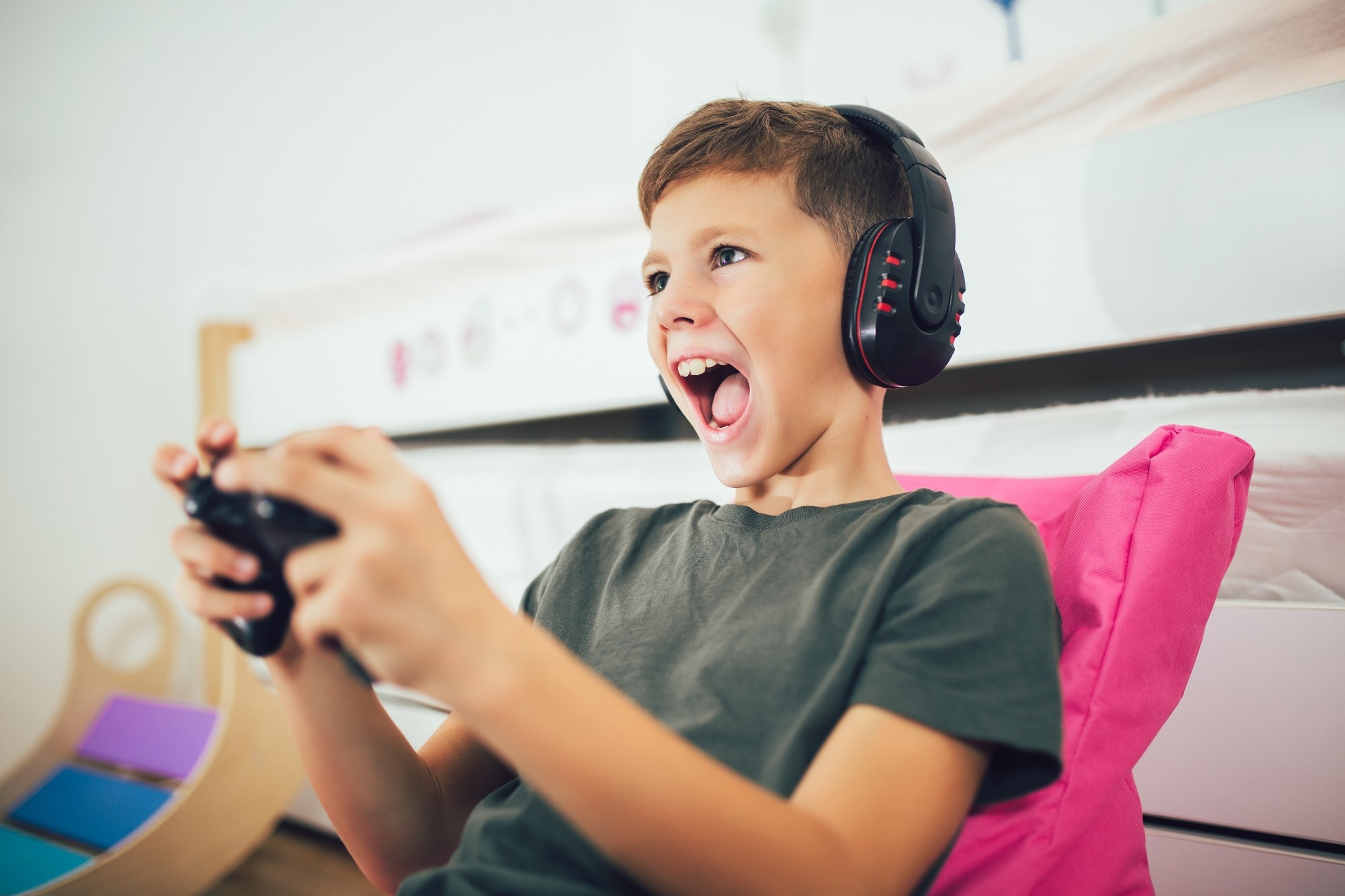 Little boy with gamepad playing video game at home