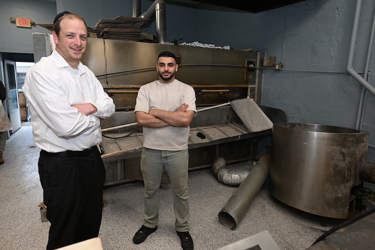 New York Bagels owner Rayyan Kayyali (right) with Rabbi Yonah Gross in front of the oven and kettle, which emerged mostly undamaged from the March 3 explosion.
