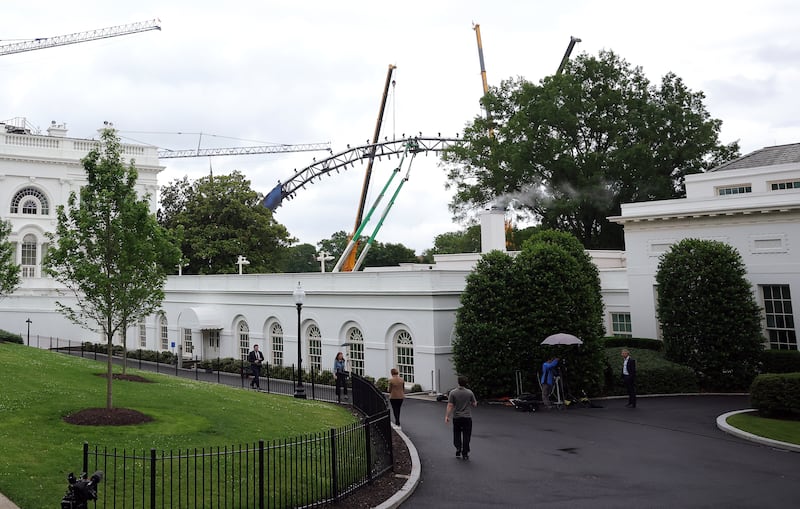 Construction crews continue to work on a structure for the upcoming UFC match on the South Lawn of the White House. Photograph: by Kevin Dietsch/Getty Images