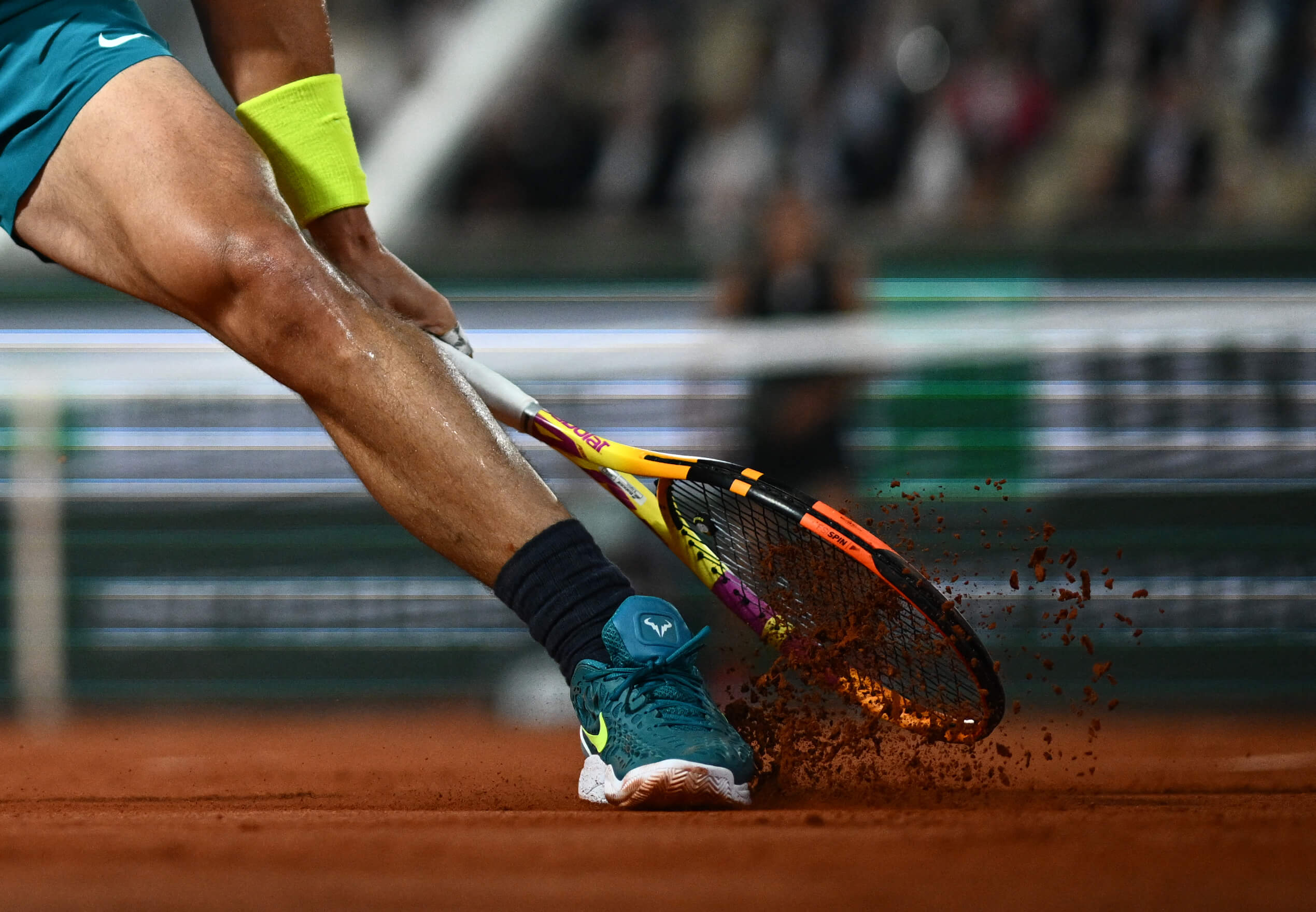 Rafael Nadal slides his left foot on a clay court.