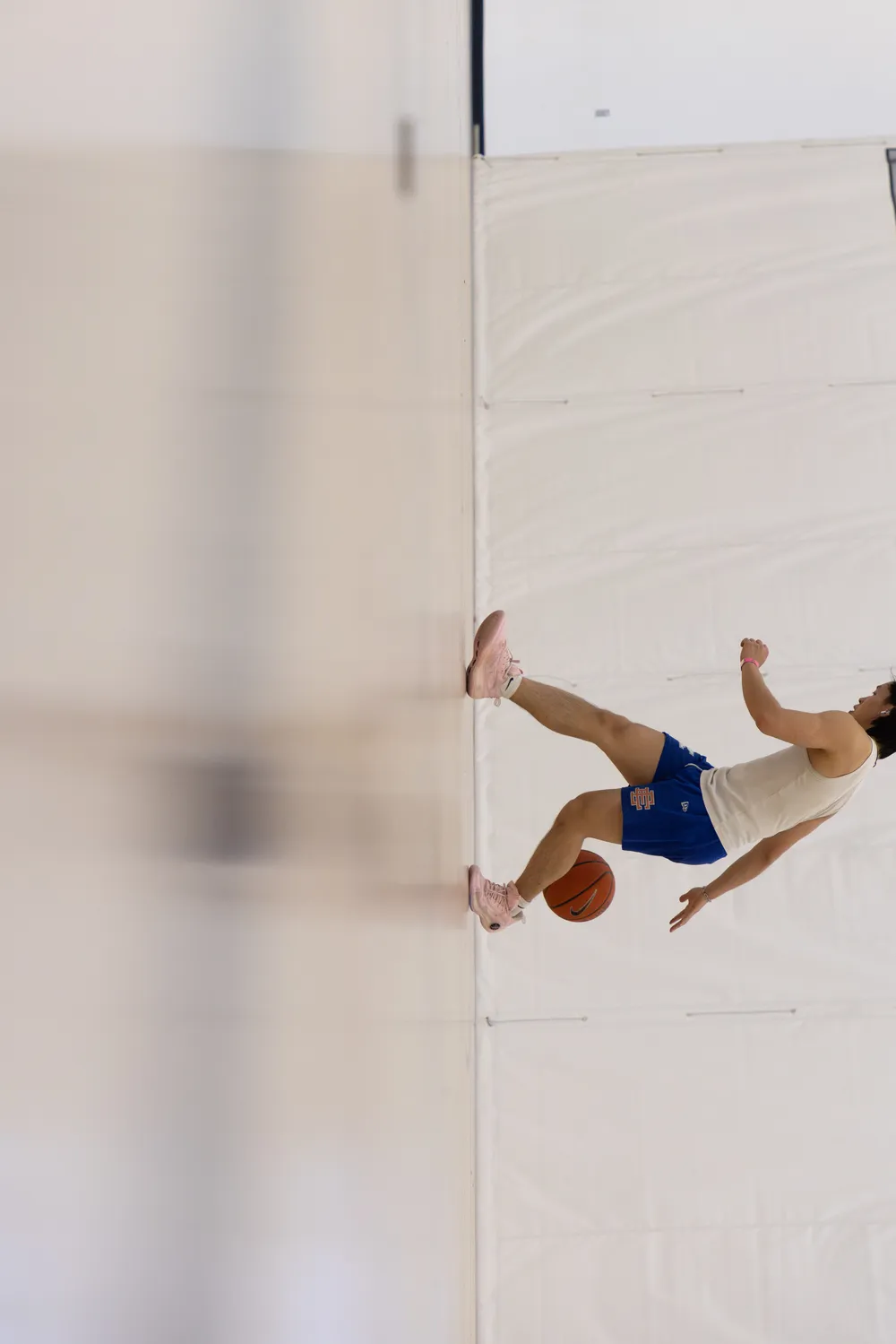 A sideways angle of a player warming up by themselves.