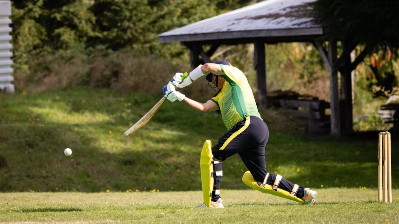 A man playing cricket outside