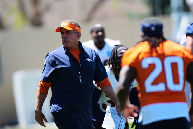 Denver Broncos head coach Sean Payton, left, looks on as rookies and free agents stretch before during drills at the NFL football team's rookie minicamp Saturday, May 9, 2026, at the team's headquarters in Centennial, Colo. (AP Photo/David Zalubowski)