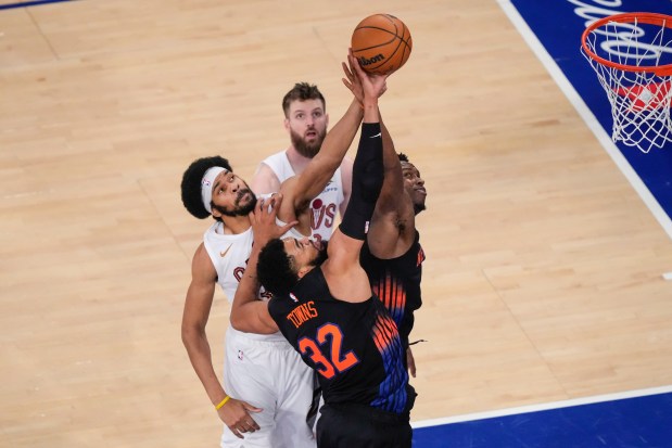 Knicks forward Og Anunoby and center Karl-Anthony Towns fight for control of the ball with Cavaliers center Jarrett Allen and forward Dean Wade on May 21 in New York. (Yuki Iwamura - The Associated Press)