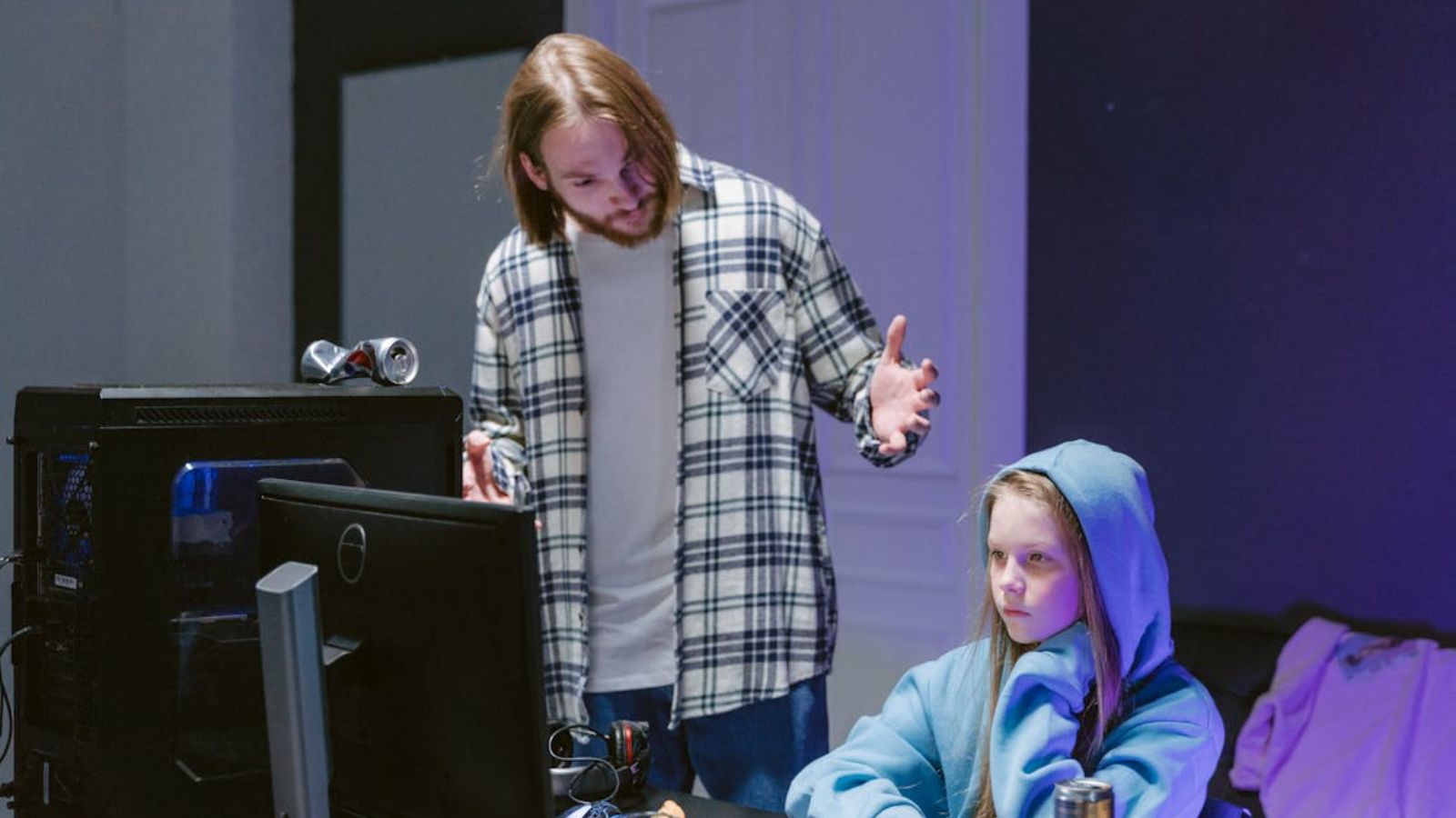 Man talking to a teenage girl while in front of computer