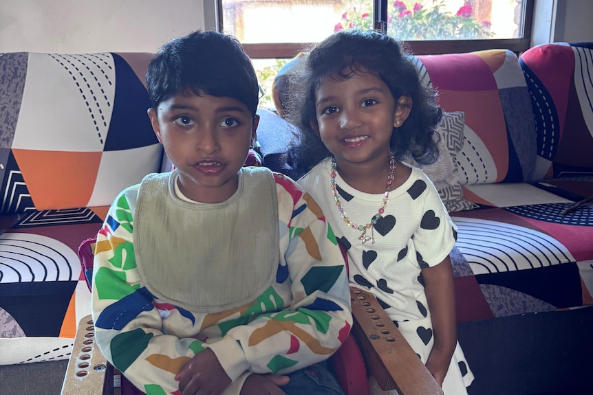 A boy and girl together in a lounge room.