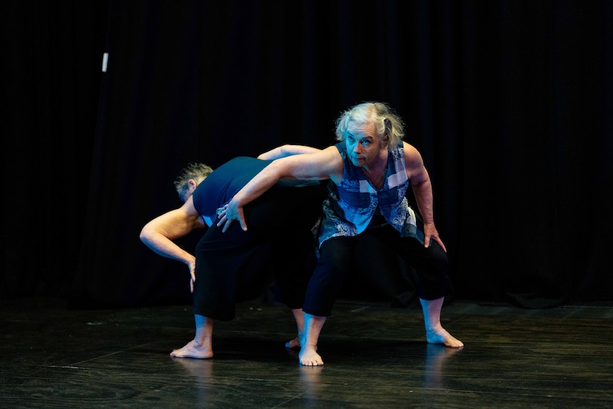 Mature-aged women doing dance practise in a studio with blue light