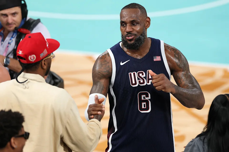 PARIS, FRANCE - AUGUST 10: LeBron James #6 of Team United States high fives former NBA player Carmelo Anthony after Team United States's victory against Team France during the Men's Gold Medal game between Team France and Team United States on day fifteen of the Olympic Games Paris 2024 at Bercy Arena on August 10, 2024 in Paris, France. (Photo by Jamie Squire/Getty Images)