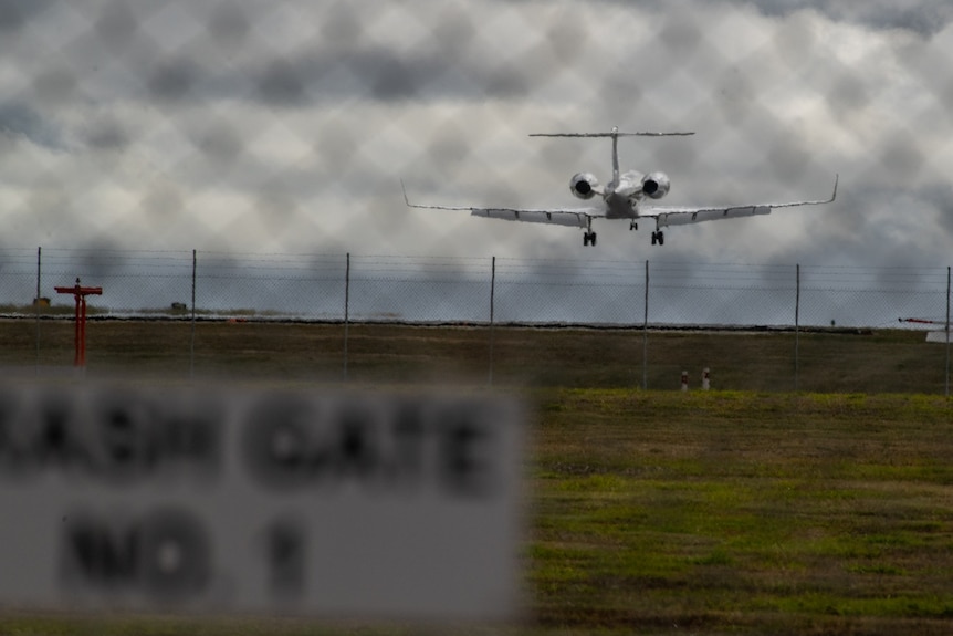 a plane can be seen landing on an airstrip