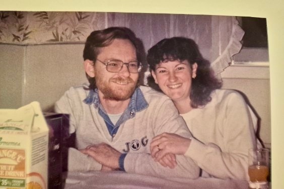 A man and woman sit smiling at a kitchen table