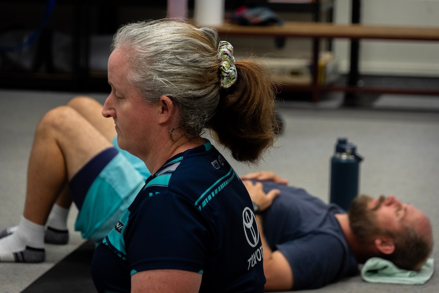 A woman with a ponytail in a blue shirt shot in profile.