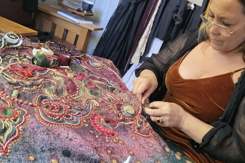 Singer Kate Ceberano hand sewing on fabric.
