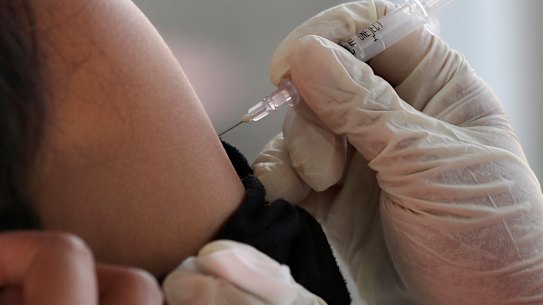 A passenger receives a shot of the Sinovac COVID-19 vaccine during a vaccination campaign at the Jakarta Kota train station in Jakarta, Indonesia, Wednesday, July 28, 2021. (AP Photo/Tatan Syuflana)