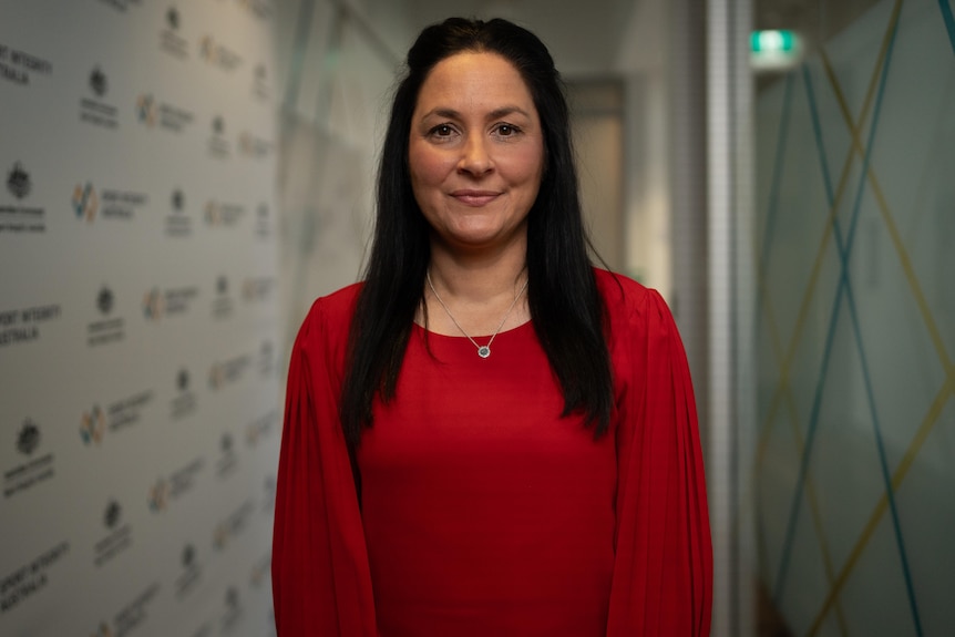 A woman with long hair, smiling.