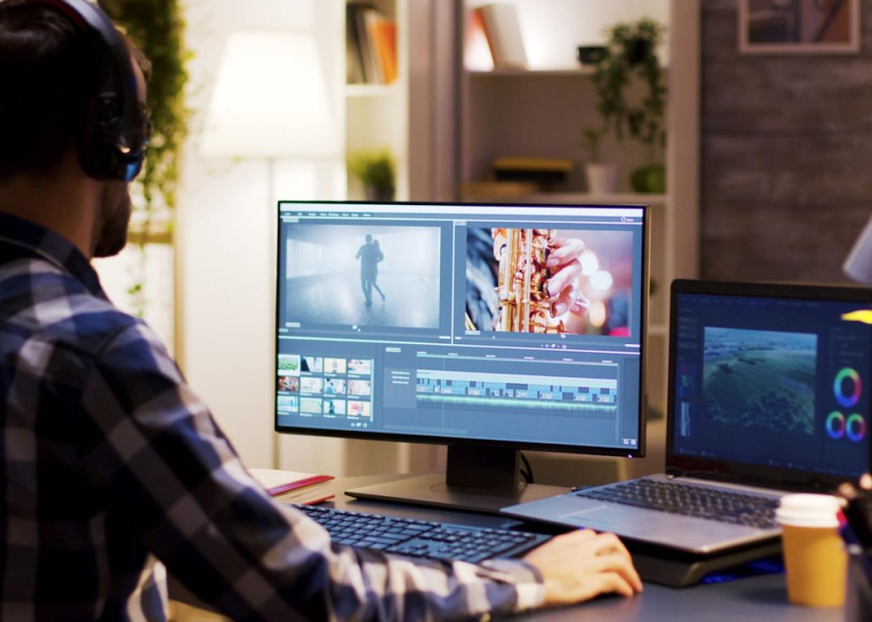 Film editor working on post production at desk. -