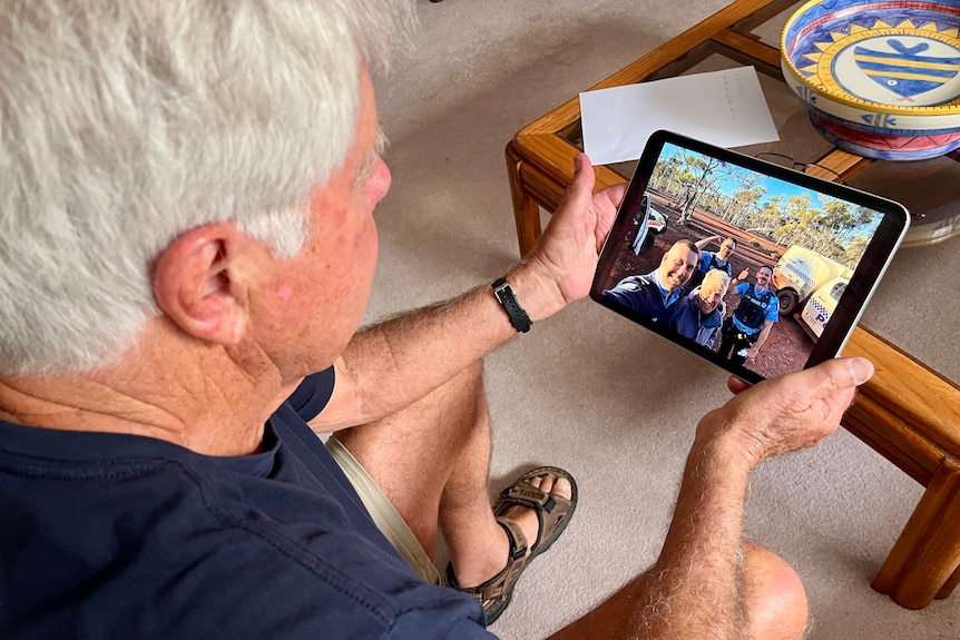 A Man looks at a photograph enlarged on a Ipad that he's holding 