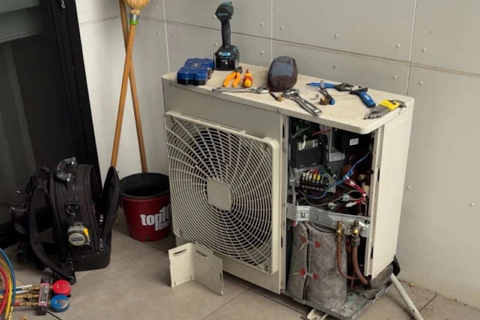 Air conditioning unit being worked on showing various tools.