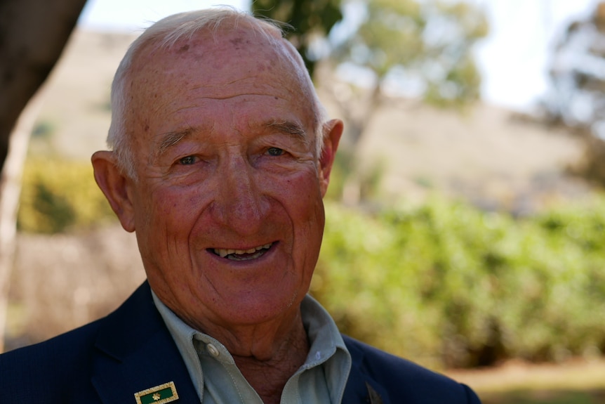 Man smiling wearing a suit.