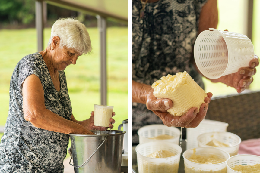 A woman tipping a molded soft cheese out of a small basket into her other hand.