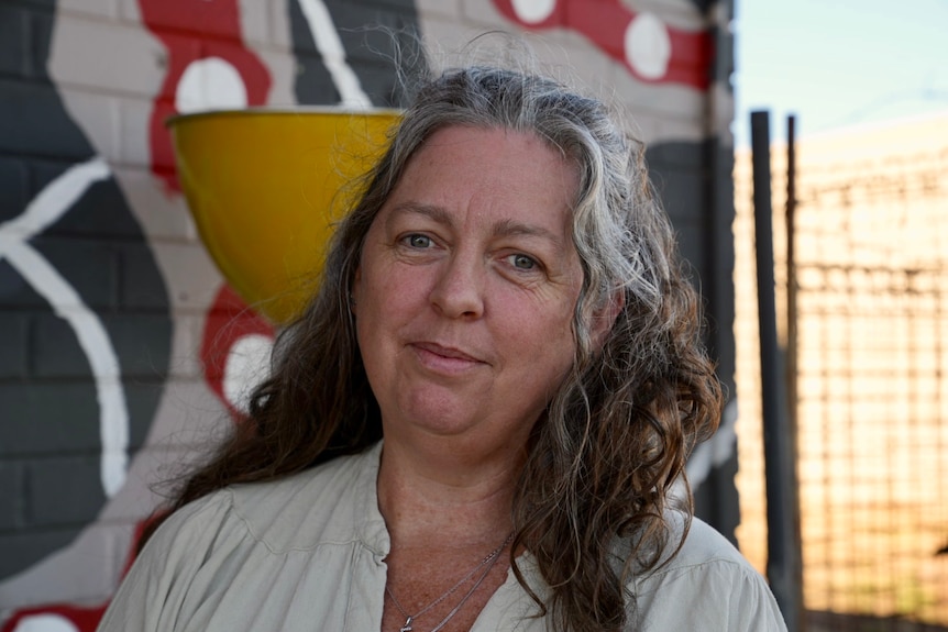 Woman with half grey and brown long hair looking at camera