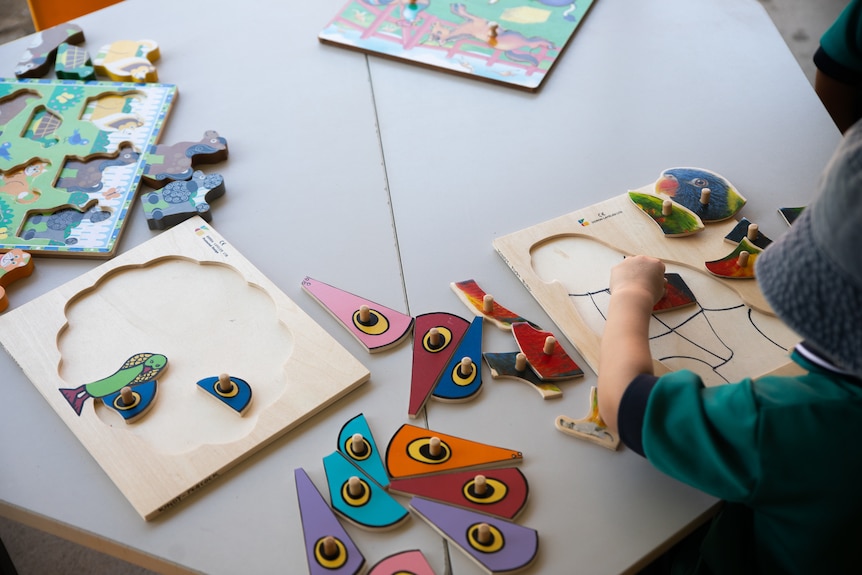 A child plays with puzzles at a table.