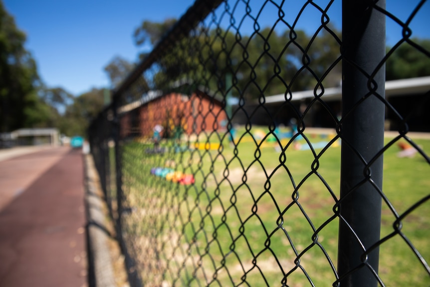A children's playground seen through a fence.