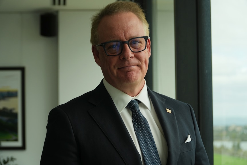 Bruce Reynolds in a suit jacket, in his council house office.