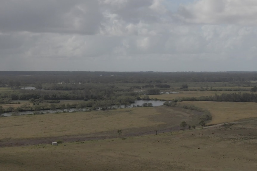 A block of land with a curving river in the background. 
