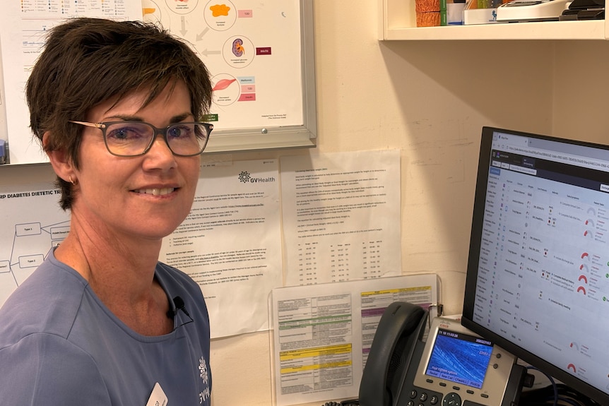 A nurse sits in front of a computer