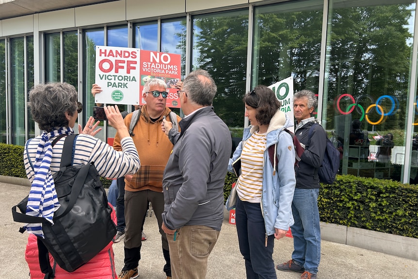 A group of protesters outside the IOC headquarters in Switzerland holding up signs.