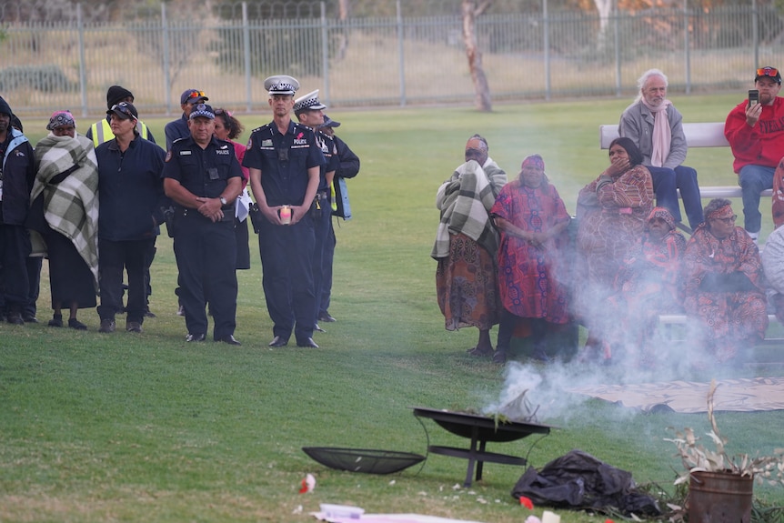 Police and Indigenous people at a smoking ceremony.