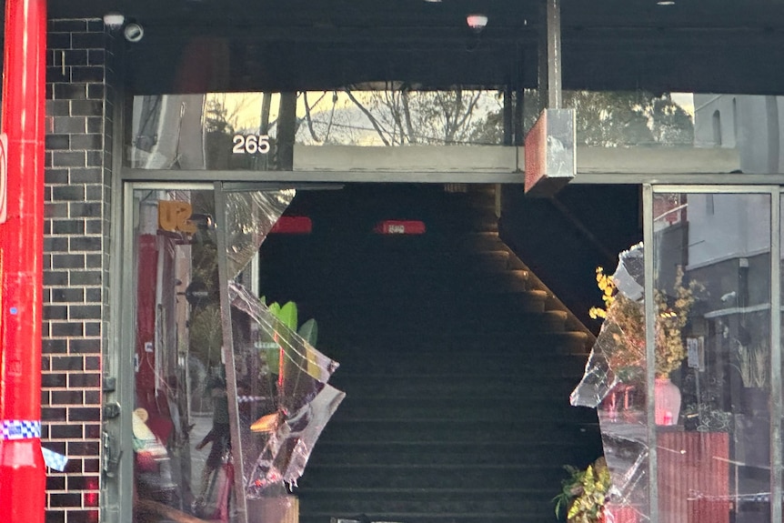 A broekn front window of a bar.