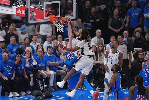 Stephon Castle of the San Antonio Spurs drives to the rim over Isaiah Hartenstein of the Oklahoma City Thunder.