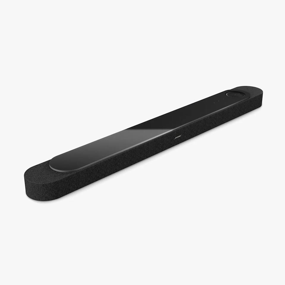 Long black Bose soundbar with fabric covering and glossy top panel on a white background.