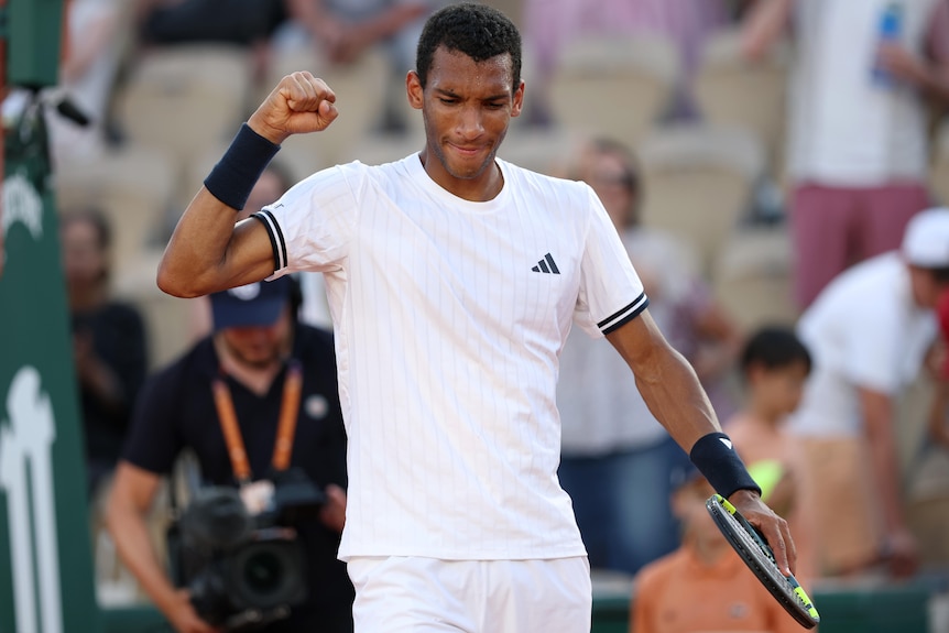 Felix Auger-Aliassime pumps his fist after winning a match at the French Open.