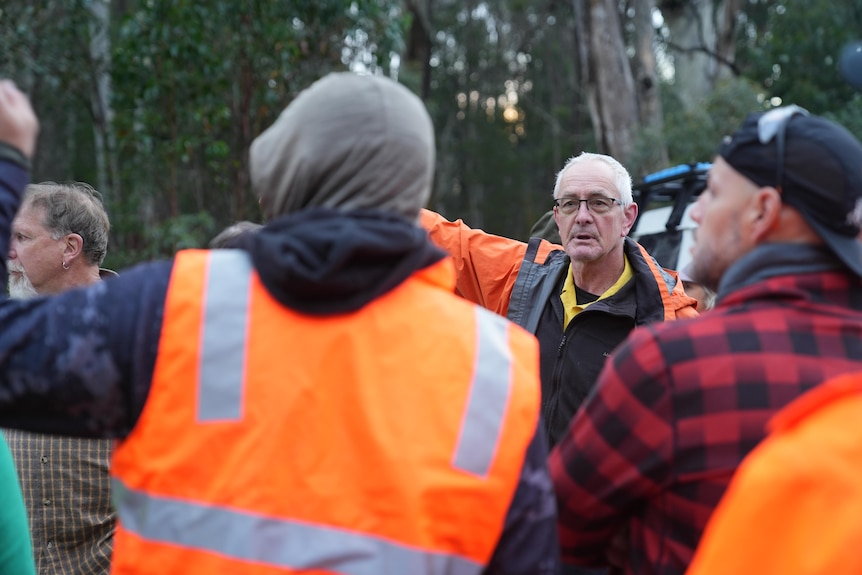 He stands with a group of volunteers