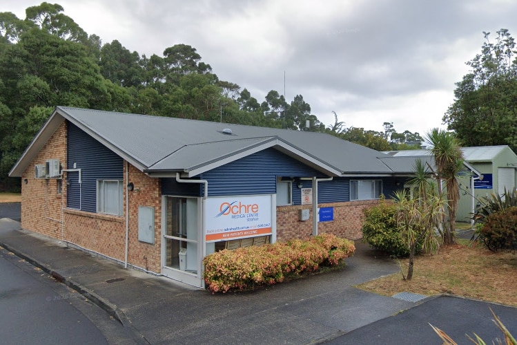 A brick building with a sign out front that says 'Ochre Medical Centre Strahan'.