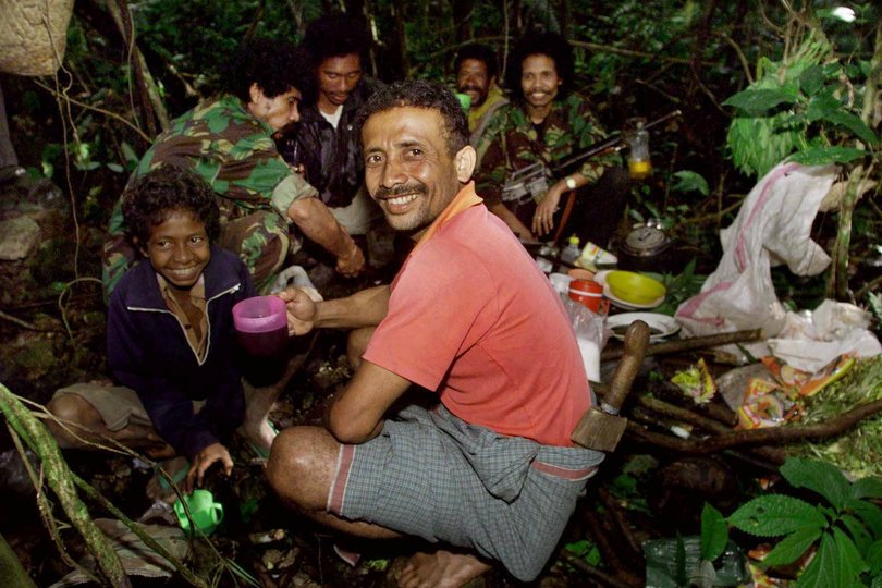 GEN "NOT OUT OF THE WOODS-YET" (8) 25/2/99 PIC: TONY ASHBY/STORY:MICHAEL D. Commander of Fretilin Lu-Olo has operated high in the mountains of East Timor since the guerilla war started 23 years ago. Pic at the small camp's kitchen of the "staff" Martino Francisco and young Antonio Paul. Picture: TONY ASHBY
