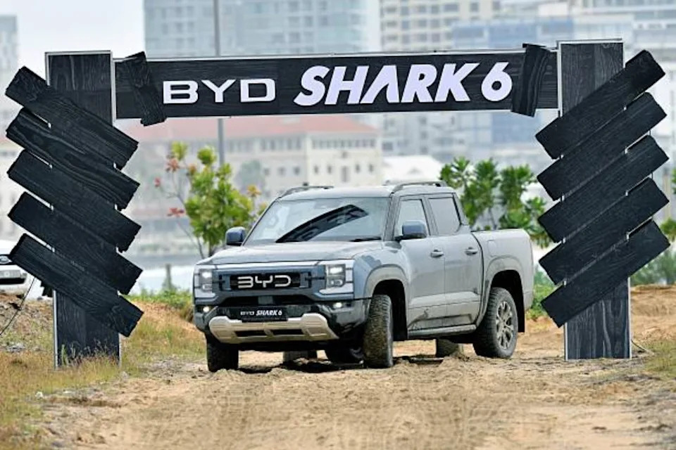A large car parked on dirt.