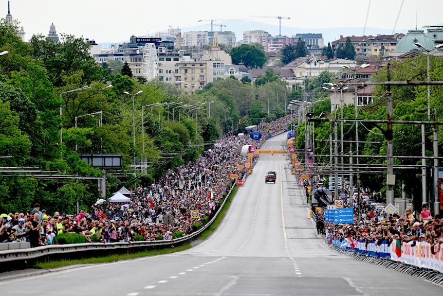 Thousands of people line the road
