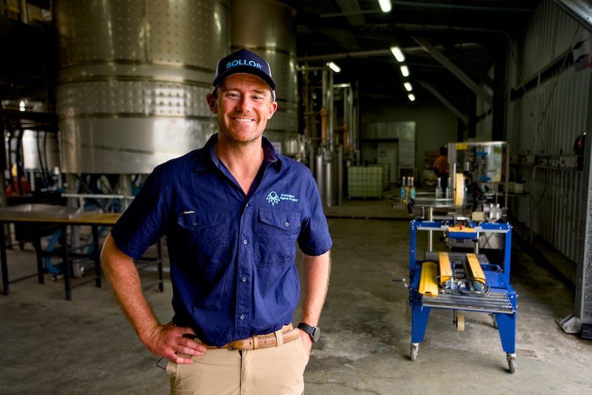 A man standing in front of a distillery machine.