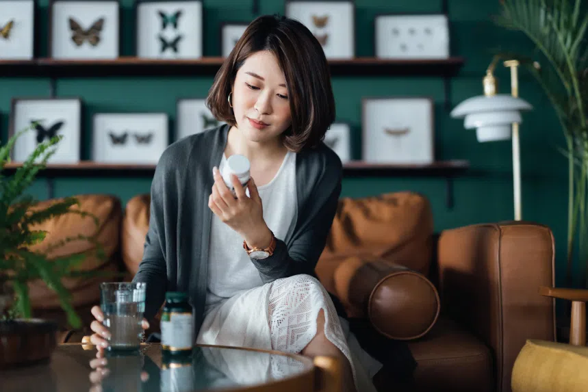 Best probiotics for women in Singapore: Asian woman reading labels on a bottle