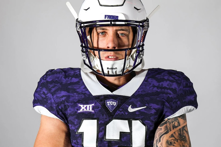 American football player wearing gear staring into camera lens.