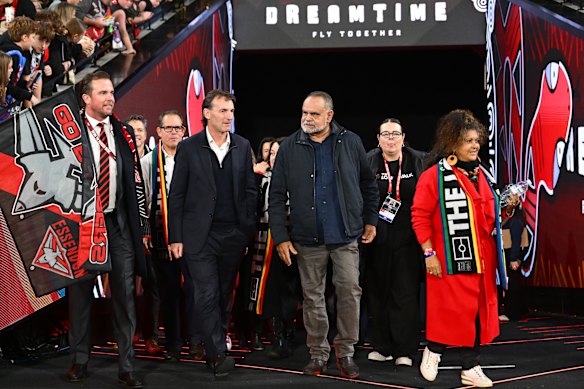 Bombers president Andrew Welsh, AFL CEO Andrew Dillon, and Essendon legend Michael Long take part in the Long Walk tonight.