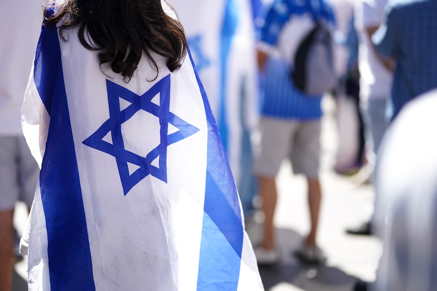 Woman wears Israeli flag on her back at pro-Israel rally