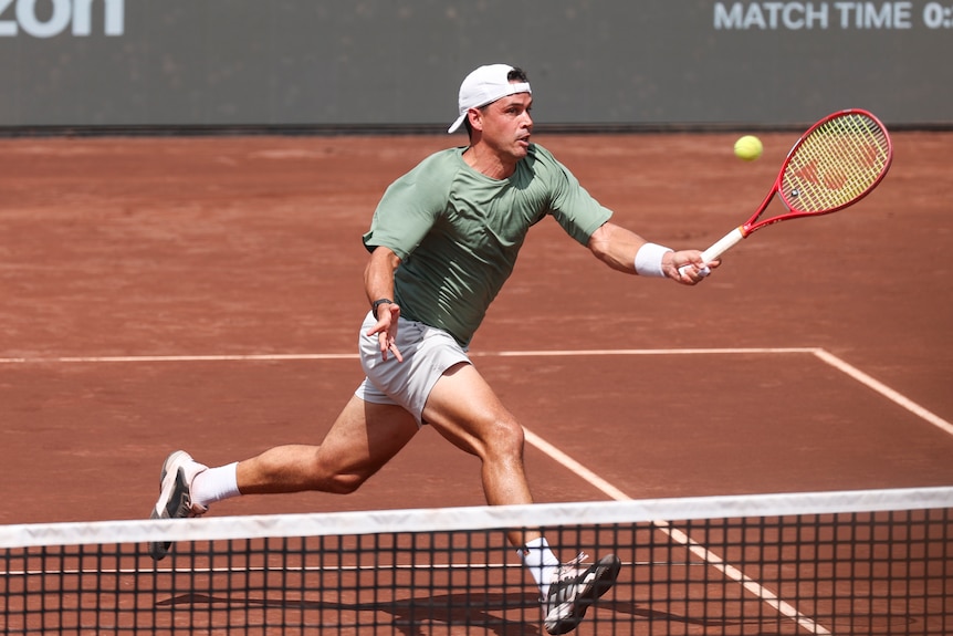 Alex Bolt plays a forehand shot on the clay court